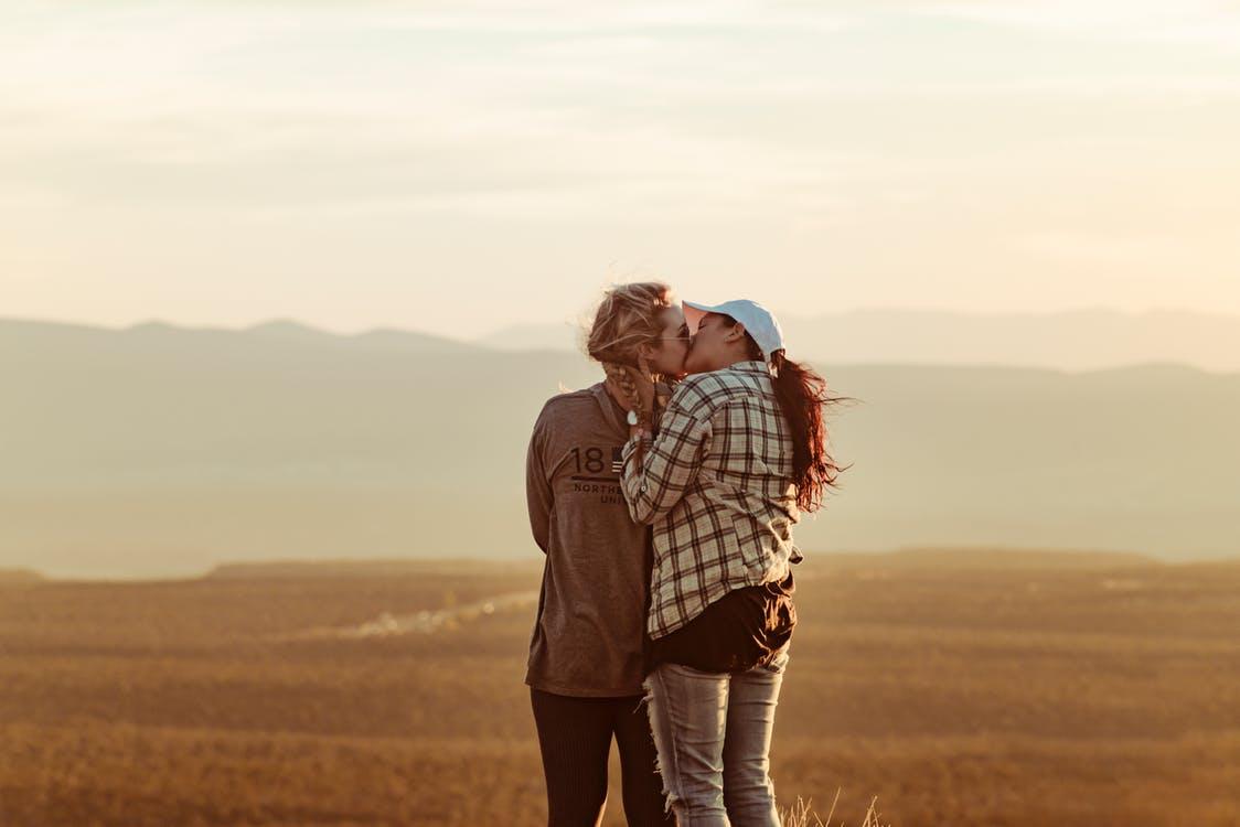 couple kissing outdoors in a field 