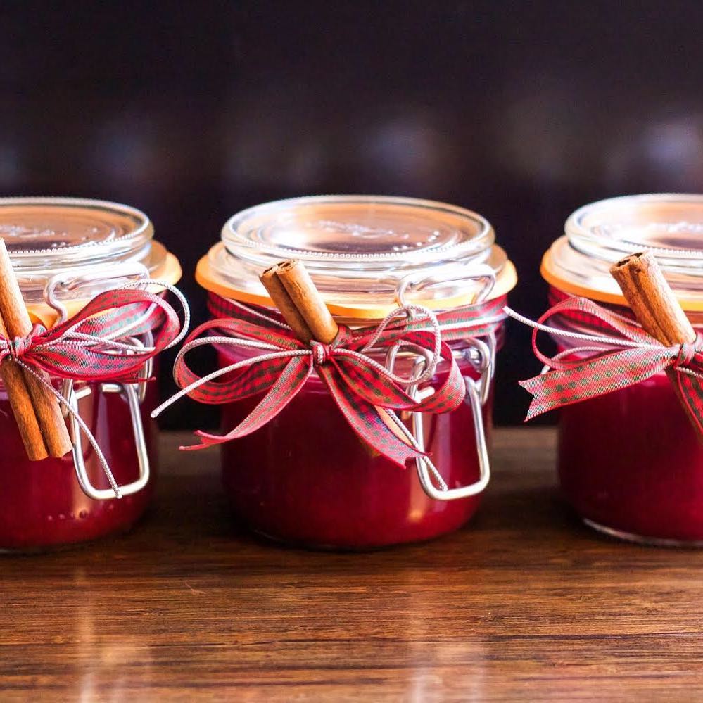 Jars of red chutney with ribbons and sticks of cinnamon